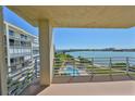 Enjoy pool and ocean views from this condo balcony featuring white railings and a calming, sunny atmosphere at 7882 Sailboat Key S Blvd # 401, South Pasadena, FL 33707