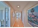 Hallway featuring hardwood floors with views of other rooms, wall art, and a built-in desk space at 7882 Sailboat Key S Blvd # 401, South Pasadena, FL 33707