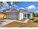 Charming single-story home featuring a well-maintained lawn, two-car garage and quaint front porch and an inviting turquoise door at 8561 Deer Chase Dr, Riverview, FL 33578