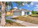 Charming single-story home featuring a well-maintained lawn, two-car garage and quaint front porch and an inviting turquoise door at 8561 Deer Chase Dr, Riverview, FL 33578