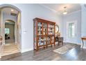 Inviting foyer showcasing hardwood floors, an arched doorway, and a stylish display cabinet at 1134 Tracey Ann Loop, Seffner, FL 33584