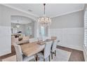 Elegant dining room featuring modern wainscoting, a chandelier, and an entry to the living room at 11624 Bristol Chase Dr, Tampa, FL 33626