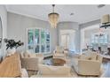 Comfortable living room featuring white chairs, a chandelier, and an arched window at 11624 Bristol Chase Dr, Tampa, FL 33626