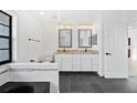 Bright bathroom featuring double sinks, granite countertops, and a separate tub area at 12062 Stone Crossing Cir, Tampa, FL 33635