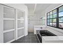 Modern bathroom with a sleek black tub, glass shower, and large window for natural light at 12062 Stone Crossing Cir, Tampa, FL 33635