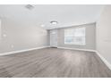 Bright living room featuring stylish gray flooring, fresh paint, and recessed lighting at 13926 Helen Ave, Hudson, FL 34667