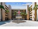 Condo exterior with palm trees and flagpole with parking lot at 14900 Gulf Blvd # 212, Madeira Beach, FL 33708