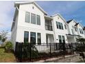 Modern two-story townhome with white siding, black windows, and a small front yard with a black fence at 1631 Springwell Ln, Sarasota, FL 34240