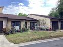Well maintained tan home with a brown roof, trimmed windows, and a lovely, landscaped yard at 2101 Sunset Point Rd # 205, Clearwater, FL 33765