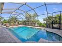 Enclosed pool with brick trim and lounge chairs offers relaxation and privacy at 2417 Cumberland Cliff Dr, Ruskin, FL 33570