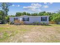 Single-story home displays a neatly kept lawn, complemented by a wooden fence and a welcoming entrance at 25126 Huston St, Brooksville, FL 34601