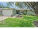 Charming single-story home featuring a well-maintained lawn and a two-car garage at 29436 Zeller Ave, San Antonio, FL 33576