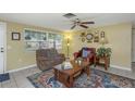 Comfortable living room with tile floors, a ceiling fan, and a cozy seating arrangement centered around a wooden coffee table at 3540 Cockatoo Dr, New Port Richey, FL 34652