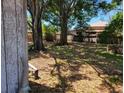 An ample backyard is displayed with mature trees and partial fence at 4708 W Ballast Point Blvd, Tampa, FL 33611