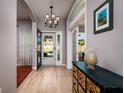 Inviting entryway showcasing wood floors, elegant light fixture, and decorative glass door at 4997 W Breeze Cir, Palm Harbor, FL 34683