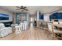 Open-concept living room featuring stylish furnishings, wood floors, and seamless flow to the kitchen and dining areas at 4997 W Breeze Cir, Palm Harbor, FL 34683