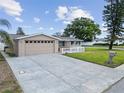 Wide shot of a home with a two-car garage, driveway, and green grass with a mailbox at 5821 Thrush Dr, New Port Richey, FL 34652
