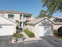 Two-story condo featuring a private balcony, vibrant green awnings, and a well-manicured, landscaped walkway at 6330 99Th N Way # 14F, St Petersburg, FL 33708