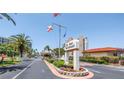Welcoming entrance to Bay Island with lush landscaping, flags, and clear signage for a beautiful first impression at 7625 Sun Island S Dr # 106, South Pasadena, FL 33707