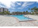 Inviting community pool surrounded by palm trees, lounge chairs, and well-maintained landscaping for relaxation at 7625 Sun Island S Dr # 106, South Pasadena, FL 33707