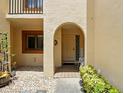 Inviting entryway with arched doorway, garden decor, and decorative tile at 8005 Bardmoor Pl # 102I, Seminole, FL 33777