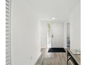Bright hallway with wood-look floors, a glass block window, and neutral walls at 8005 Bardmoor Pl # 102I, Seminole, FL 33777