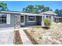 Charming single-story home with gray siding, stone accents, and a well-maintained front yard at 10931 110Th Ave, Seminole, FL 33778