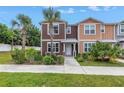 Beautiful townhome with palm trees, landscaped yard, and inviting front entrance at 1116 Martin Luther King Jr Ave, Dunedin, FL 34698