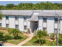 Inviting condo exterior with lush landscaping and a well-maintained facade with stairs to the second floor at 112 W Cypress Ct, Oldsmar, FL 34677