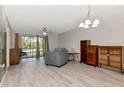 Bright living room features updated floors and abundant natural light streaming through the sliding glass doors at 112 W Cypress Ct, Oldsmar, FL 34677