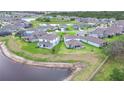 Aerial view featuring houses surrounding a lake and green spaces in the community at 12905 Brookside Moss Dr, Riverview, FL 33579