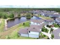 Overhead view of a suburban neighborhood featuring homes surrounding a tranquil pond at 12905 Brookside Moss Dr, Riverview, FL 33579