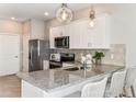 Bright kitchen features granite countertops, stainless steel appliances, and stylish pendant lighting at 13084 Stillmont Pl, Tampa, FL 33624