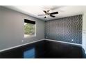Bedroom with dark wood floors, ceiling fan, and unique wallpaper at 1400 Gandy N Blvd # 708, St Petersburg, FL 33702