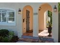 Inviting entryway with tiled porch, arched openings, decorative lighting, and a stylish front door at 1606 at 1606 S Arrawana Ave, Tampa, FL 33629