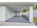 Spacious carport featuring modern flooring, fresh paint, and a convenient side entrance at 16411 Lake Byrd Dr, Tampa, FL 33618
