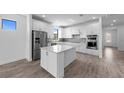 Bright, open kitchen with stainless steel appliances, island, white cabinets, and modern finishes at 17093 Moonflower Dr, Venice, FL 34293
