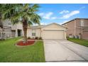 Charming single-story home featuring a well-manicured lawn and attached two-car garage at 17413 Garden Heath Ct, Land O Lakes, FL 34638