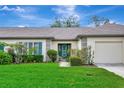 Inviting home exterior with green front door, shutters, green lawn, and mature landscaping at 18807 Tournament Trl, Tampa, FL 33647