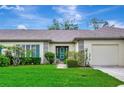 Beautiful home featuring a lush green lawn and inviting curb appeal with charming green shutters at 18807 Tournament Trl, Tampa, FL 33647