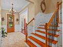Bright foyer boasts a wood staircase, tiled floors, and a clear view through the front door at 1915 Floresta View Dr, Tampa, FL 33618