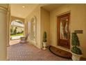 Inviting front porch featuring brick pavers, decorative columns, and a beautifully crafted wooden front door at 1915 Floresta View Dr, Tampa, FL 33618