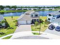 Aerial view of a two-story home with a well-maintained lawn, a large driveway, and lush landscaping at 2563 Ocean Breeze Ln, Clearwater, FL 33761