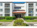 Well-maintained condominium entrance with glass doors, manicured landscaping, and visible accessibility signage at 2595 Countryside Blvd # 8205, Clearwater, FL 33761