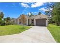 Beautifully landscaped home featuring a concrete driveway and a neatly maintained front yard at 3803 E Curtis St, Tampa, FL 33610