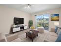 Bright living room with sliding door to balcony and comfortable seating arrangement at 381 S Mcmullen Booth Rd # 72, Clearwater, FL 33759