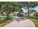 Attractive exterior view showing the home's paved driveway, tidy lawn, and mature landscaping at 430 44Th Ne Ave, St Petersburg, FL 33703