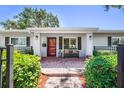 Inviting front porch with a brick walkway, stylish bench, and well-maintained landscaping at 430 44Th Ne Ave, St Petersburg, FL 33703