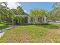Charming single-story home with a well-manicured lawn and an inviting, plant-covered archway entrance at 433 San Salvador Dr, Dunedin, FL 34698