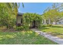 Quaint front entrance featuring a vine-covered archway, a cozy chair, and a welcoming walkway at 433 San Salvador Dr, Dunedin, FL 34698